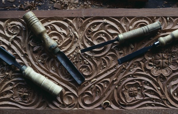 KENYA, Lamu Island, Traditional Swahili culture wood carving detail with tools lying on top