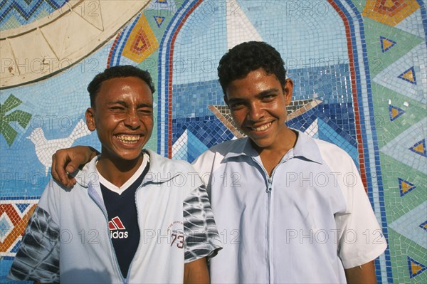 EGYPT, Nile Valley, Aswan, "Two smiling boys, one with arm resting across shoulders of other. "