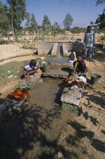 INDIA, Andhra Pradesh, Anantapur, Women washing clothes in irrigation outlet