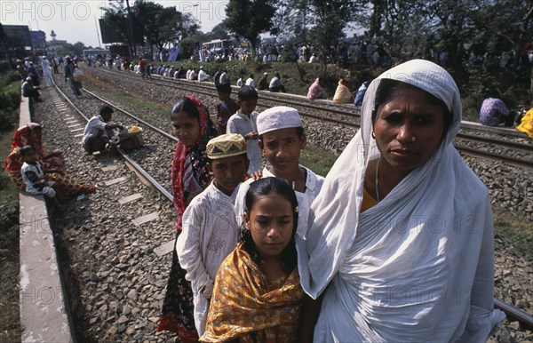 BANGLADESH, Dhaka, Muslim men and women gathered along the railway track at Biswas Ijtema with woman and children in the foreground