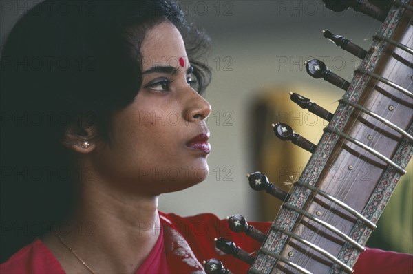INDIA, Music, Female Indian musician playing the sitar.  Cropped view showing neck of instrument only.
