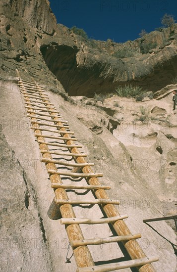 USA, New Mexico, Bandalier, Wooden ladder into Anasazi Indian cave dwelling in the national monument