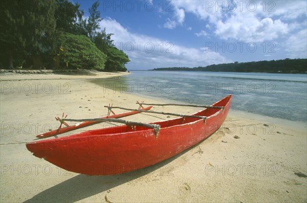 PACIFIC ISLANDS, Melanesia, Vanuatu Islands, Efate Island.  Red outrigger canoe moored on sandy beach of resort island of Erakor south of the capital Port Vila.