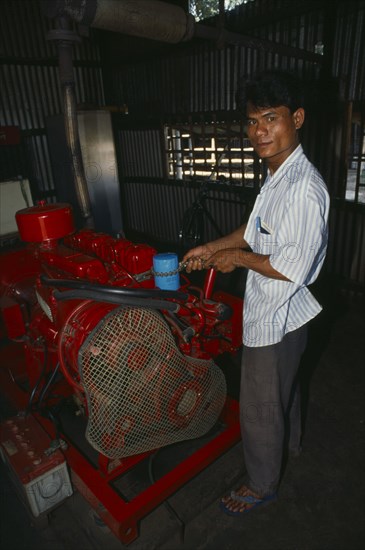 BANGLADESH, Mymensingh, Mechanic maintaining diesel generator.