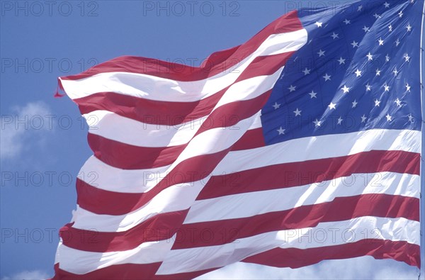 FLAGS, USA, Close up of the stars and stripes flag against a blue sky