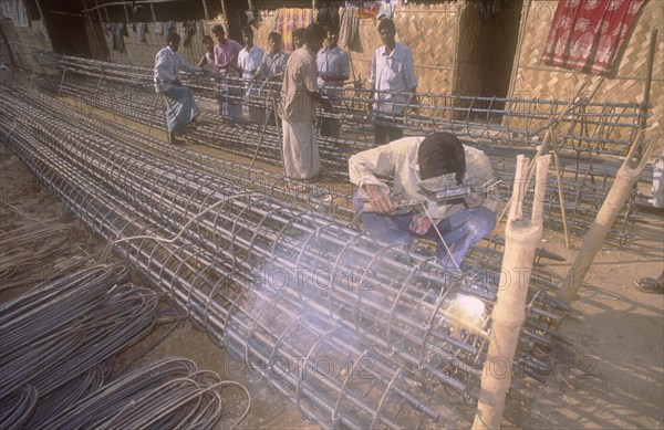 BANGLADESH, Dhaka, Welder welding the in suite reinforcement of a concrete pile of a high rise building.