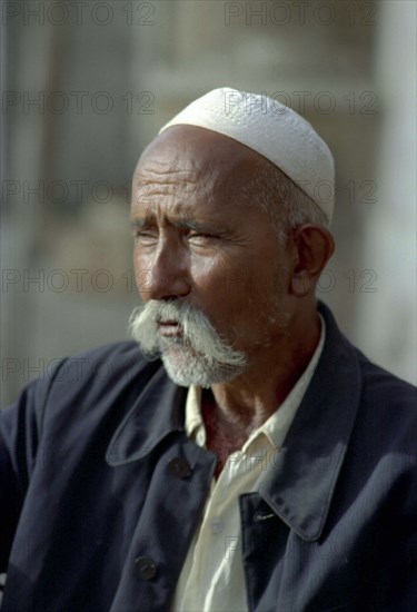 CHINA, Xinjiang, Kashgar, Portrait of a man wearing a cap