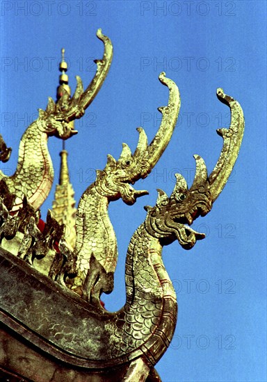 LAOS, Savannakhet, Wat Sainyamungkhun. Golden roof detail of Guardians in the form of dragons used to keep evil spirits away
