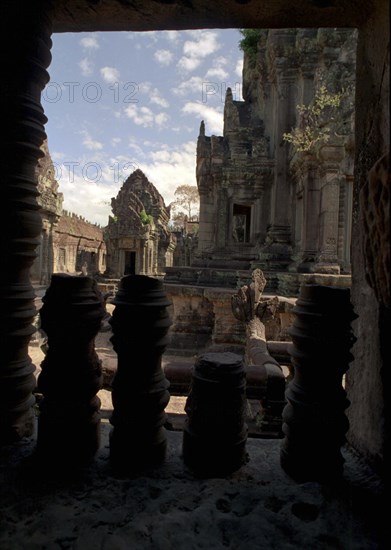 CAMBODIA, Angkor, View through archway over pink sandstone ruins of Banteay Srei or The Citadel of the Women