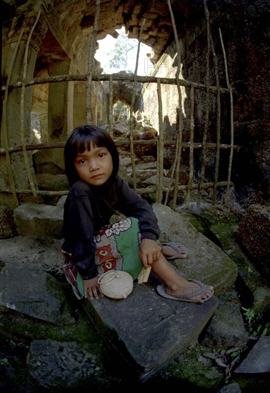 CAMBODIA, Seim Reap, Girl sitting at Banteay Srei or The Citadel of the Women where children act as guides to earn money for schooling
