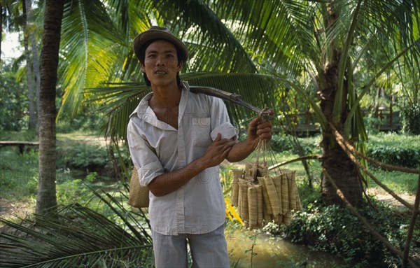 VIETNAM, Giang Province, Roadside vendor selling sticky rice wrapped in banana leaves.