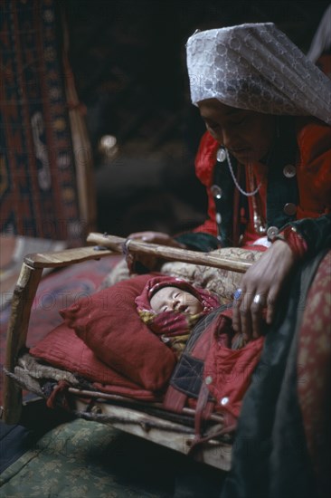 AFGHANISTAN, People, Kirghiz woman with baby inside yurt.