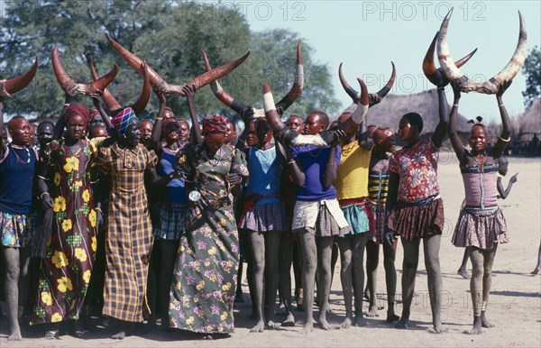 SUDAN, Tribal Peoples, Dinka cattle festival or Toich.  Women holding painted bulls horns in the air.