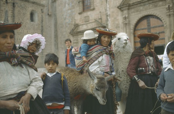 PERU, Cuzco, Quechua women and children with lamas.