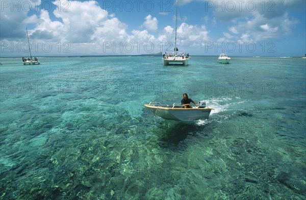 MAURITIUS, Isle Gabriel, Man riding speedboat on turquoise sea