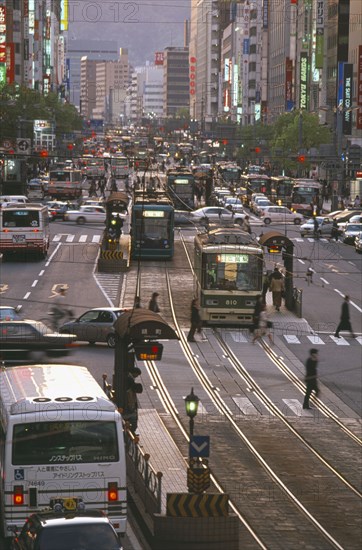 JAPAN, Honshu, Hiroshima, Aioi Street with city traffic either side of a central tram line and skyscrapers on each side of the road