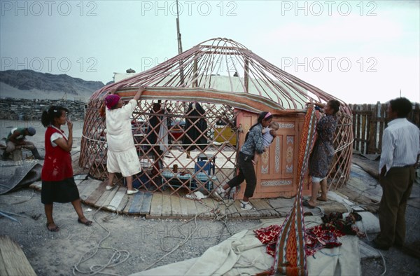 MONGOLIA, Nomadic People, Women erecting framework for a yurt.