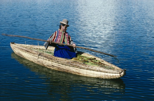 PERU, Puno, Lake Titicaca, Uros woman on reed boat rowing to floating island.