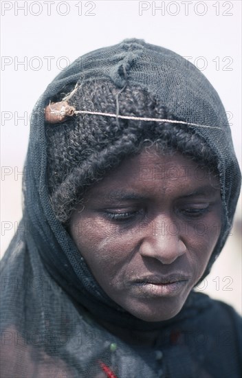 ETHIOPIA, Danakil Depression, Portrait of Afar woman with verses of the Koran tied around her head to cure migraine.