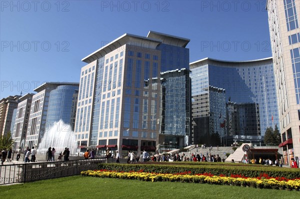 CHINA, Beijing, Modern city architecture with red and yellow flowerbeds in the foreground