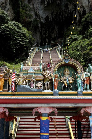 MALAYSIA, Near Kuala Lumpur, Batu Caves, View looking up the steep teps toward the Cave entrance with colourful statues atop columned archway in the foreground
