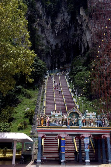 MALAYSIA, Near Kuala Lumpur, Batu Caves, View of steep stairway leading up in to the caves with colourful statue covered arch at the bottom