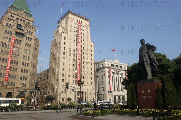 CHINA, Shanghai, The Bund aka Zhong Shan Road. 1930s style waterfront architecture including the Peace Hotel and the Bank of China with statue of Mao in the foreground