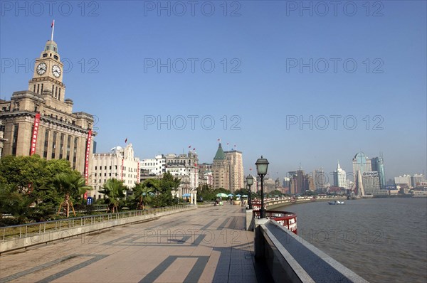 CHINA, Shanghai, The Bund aka Zhong Shan Road. View along the promenade that runs along the Huangpu River with the city skyline in the distance