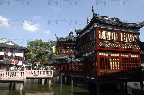 CHINA, Shanghai, Yuyuan Gardens. Bridge leading to traditional style architecture built on stilts over water