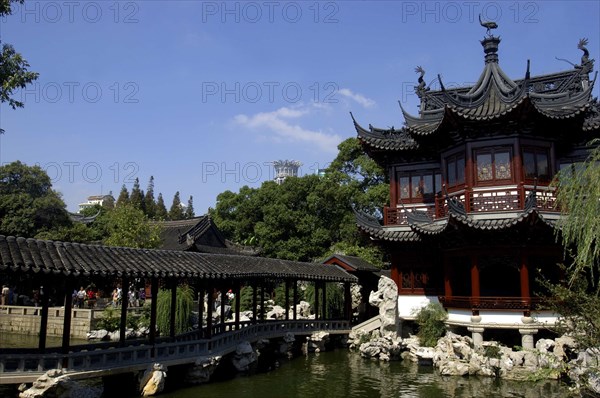 CHINA, Shanghai, Yuyuan Gardens. Covered bridge leading toward traditional style architecture built over water