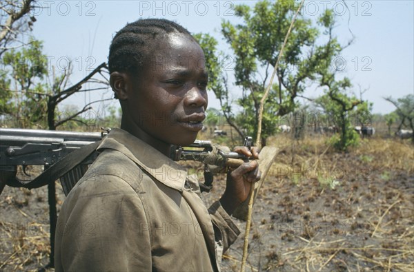 UGANDA, North, Portrait of a Karamojong tribesmen with an automatic weapon guarding cattle near Lira against border raids from the Turkana people of Kenya