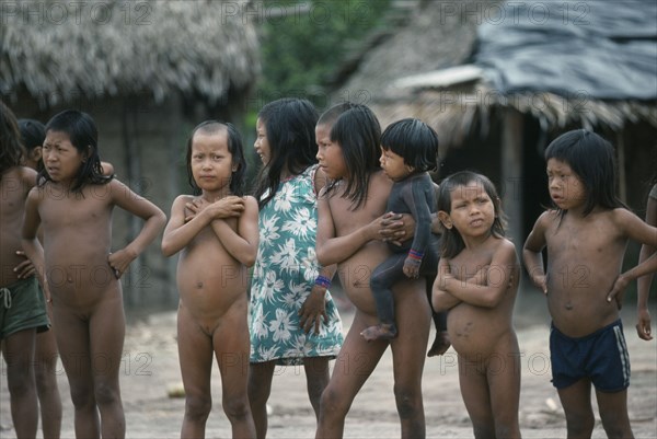 BRAZIL, Amazon, Xikrin children with strips of shaved hair and one small child with body painted with black genipapo dye.