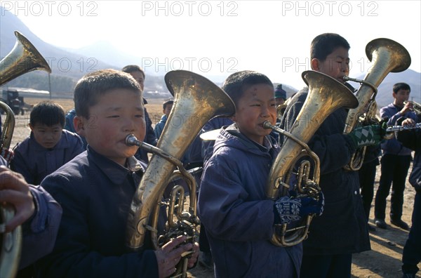 NORTH KOREA, Hwanghae Bukto, Juche ideology. Pyongsan County band encouraging workers as they repair flood dykes.