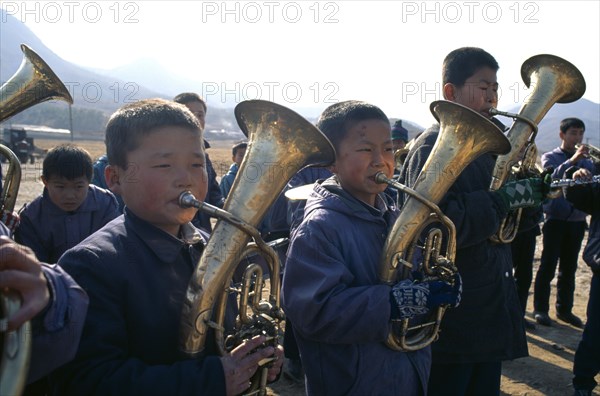 NORTH KOREA, Hwanghae Bukto, Juche ideology.  Pyongsan County band encouraging workers as they repair flood dykes.