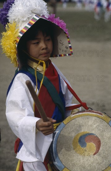 SOUTH KOREA, Seoul, Little girl in costume playing drum painted with Taegukki symbol during Childrens Day festivities in May.