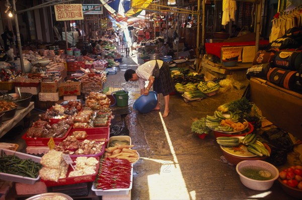 SOUTH KOREA, Kangwon, Sokcho, Women rinsing bowl at street market selling fruit and vegetables and kimchi in east coast fishing port.