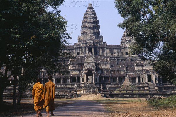 CAMBODIA, Siem Reap, Angkor Wat, Two monks walking on the east road leading to the rear of the main temple building