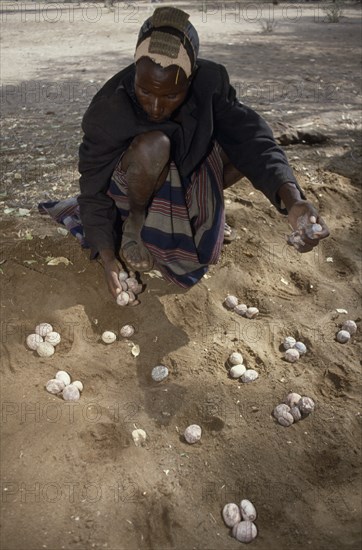 KENYA, North, People, Turkana man playing traditional mathematical game of Ajua.