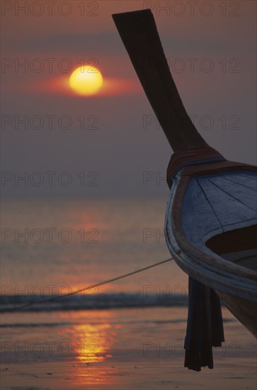 THAILAND, Krabi, Koh Lanta Yai, Klong Dao beach at sunset with the bow of a fishing boat pointing out to sea