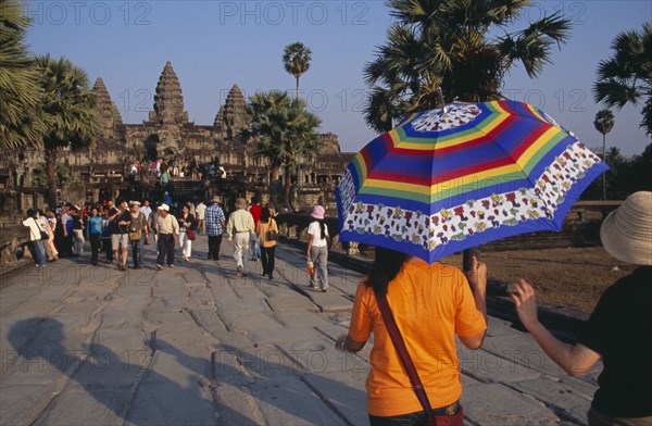 CAMBODIA, Siem Reap Province, Angkor Wat, Tourists on stone causeway leading to temple complex.  Many Cambodians visiting during Chinese New Year.