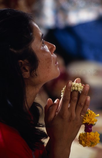 THAILAND, South, Bangkok, Wat Meuang the City pillar the most important animist shrine in Bangkok with female devotee praying