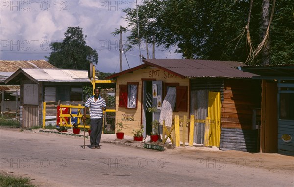 GUYANA, Timemri, Man standing outside a snackette shop at Timemri International Airport.