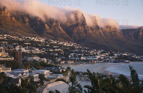 SOUTH AFRICA, Western Cape, Cape Town, Camps Bay. View from Lions Head along the coastline and the Twelve Apostles mountain cliffs covered in a blanket of cloud