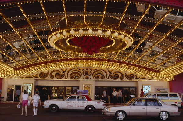 USA, Nevada, Las Vegas, Brightly lit red and gold Hotel Casino with taxi cabs parked outside.