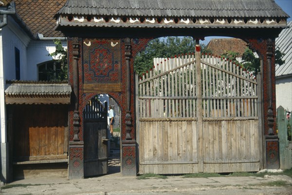 ROMANIA, Transylvania, Woodcarvers house with elaborately carved gateway decorated with plant and bird motifs.