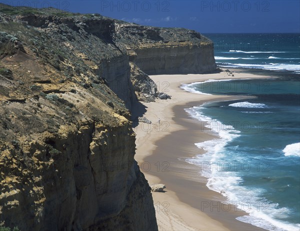 AUSTRALIA, Victoria, Near Port Campbell, Great Ocean Road. View along rugged rocky cliffs and sandy beach