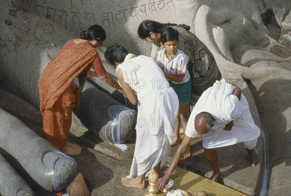 INDIA, Karnataka, Sravanabelagola, Jain holy site and pilgrimage centre.  Puja at feet of statue of Bahubali or Gomateshvara.