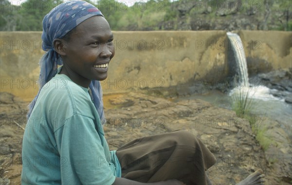 KENYA, Kipsaraman, Pauline Rerimoi beside dam she built.  Previously she had had to carry a twenty litre container of water along cliff paths in a four hour trip.