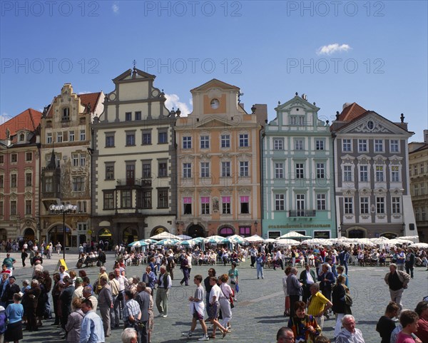 CZECH REPUBLIC, Stredocesky, Prague, Stare Mesto. Crowds of people in Old Town Square with line of buildings with art nouveau style facades behind.