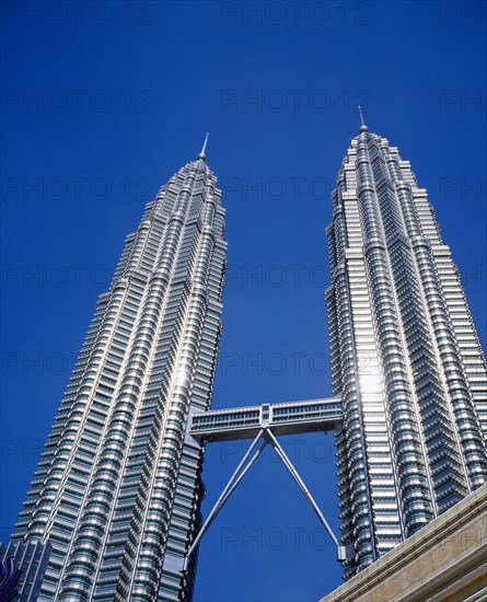 MALAYSIA, Kuala Lumpur, Petronas Twin Towers. Angled view looking up at the multi storey buildings housing corporate headquarters against a blue sky